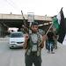A Free Syrian Army soldier holds a rifle and a Syrian flag at the Bab al-Salam border crossing to Turkey on July 22, 2012.