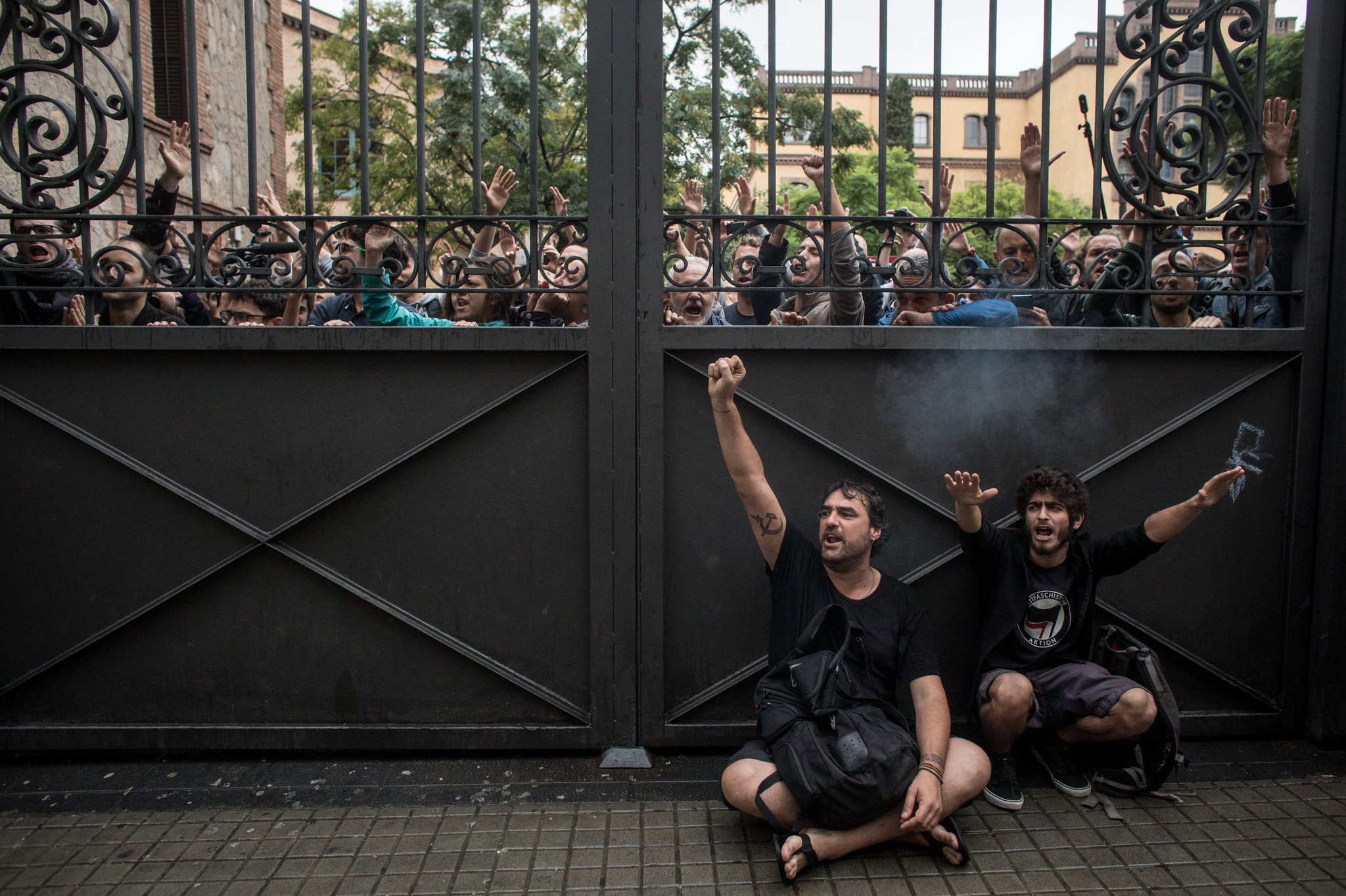 Pro-referendum supporters blocked a gate to a polling station in Barcelona as members of the Spanish police arrived to control the area. Credit Chris Mcgrath/Getty Images