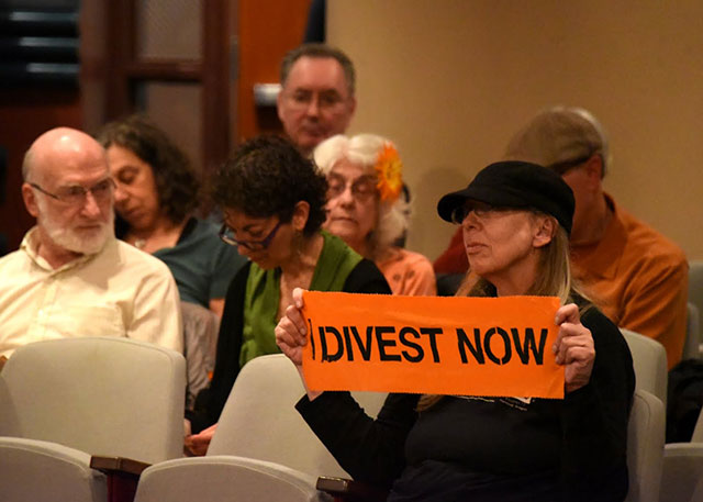 An activist calls for divestment at a Portland City Council meeting last week. The council's decision to divest from all corporations was a victory for activists organized along intersectional lines. (Photo: Doug Yarrow)
