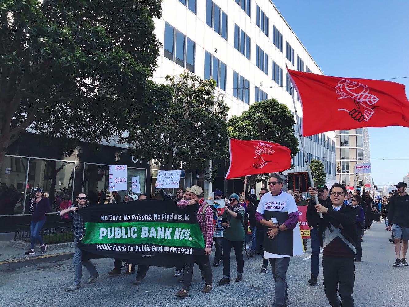 Members of the San Francisco Public Bank Coalition march to San Francisco City Hall to demand the city divest from Wall Street and create a public bank. - KURTIS WU