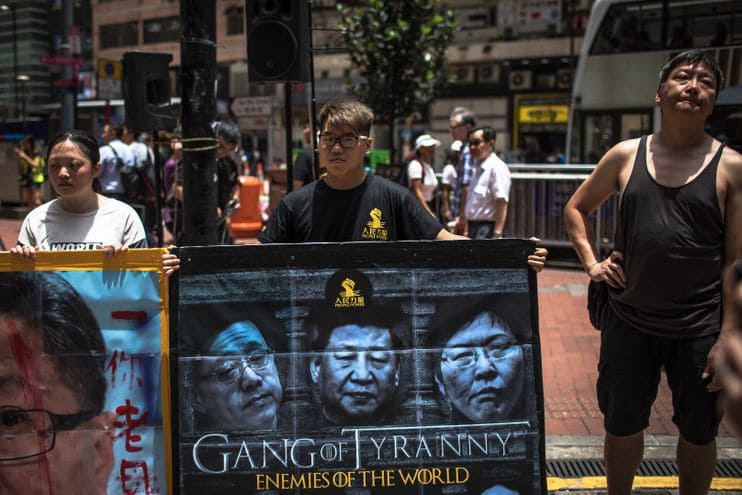 Protesters hold a banner with images of Chinese President Xi Jinping, center, and Lam, right. (Roman Pilipey/EPA-EFE/Shutterstock)