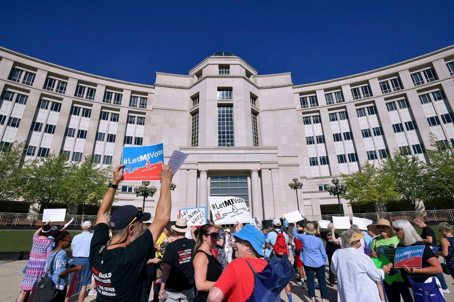 Demonstrators rally outside the Michigan Hall of Justice in Lansing, Mich., where the state’s Supreme Court heard arguments in July about whether voters in November would be able to pass a constitutional amendment that would change how the state’s voting 