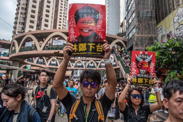 Protesters hold posters of Hong Kong’s embattled leader Carrie Lam. (Carl Court/Getty Images)