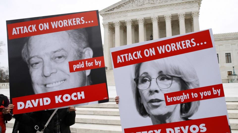 Members of the American Federation of Teachers hold up signs depicting Education Secretary Betsy DeVos and David Koch, while protesting in support of unions outside of the supreme court on 26 February. Photograph: Jacquelyn Martin/AP