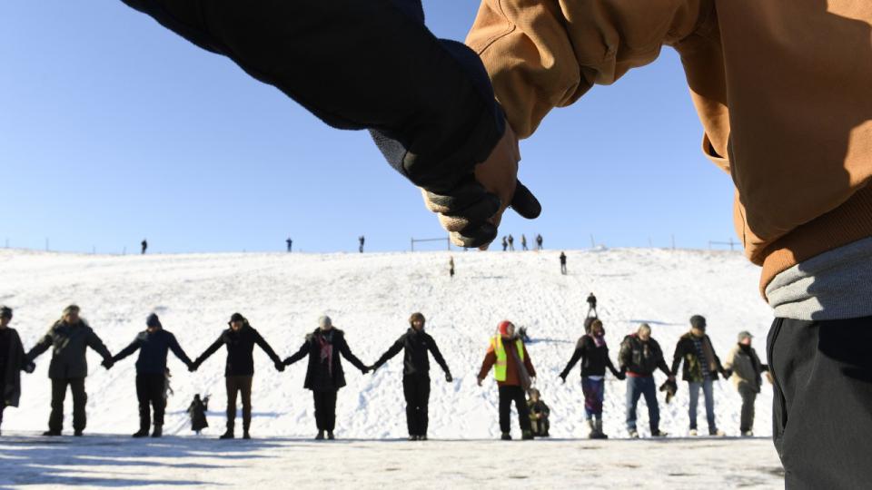 US VETERANS AND NATIVE AMERICANS HOLD HANDS IN PRAYER AND SOLIDARITY ON THE ROAD NEAR OCETI SAKOWIN CAMP ON THE EDGE OF THE STANDING ROCK SIOUX RESERVATION ON DECEMBER 4, 2016 OUTSIDE CANNON BALL, NORTH DAKOTA. (CREDIT: HELEN H. RICHARDSON/THE DENVER POST