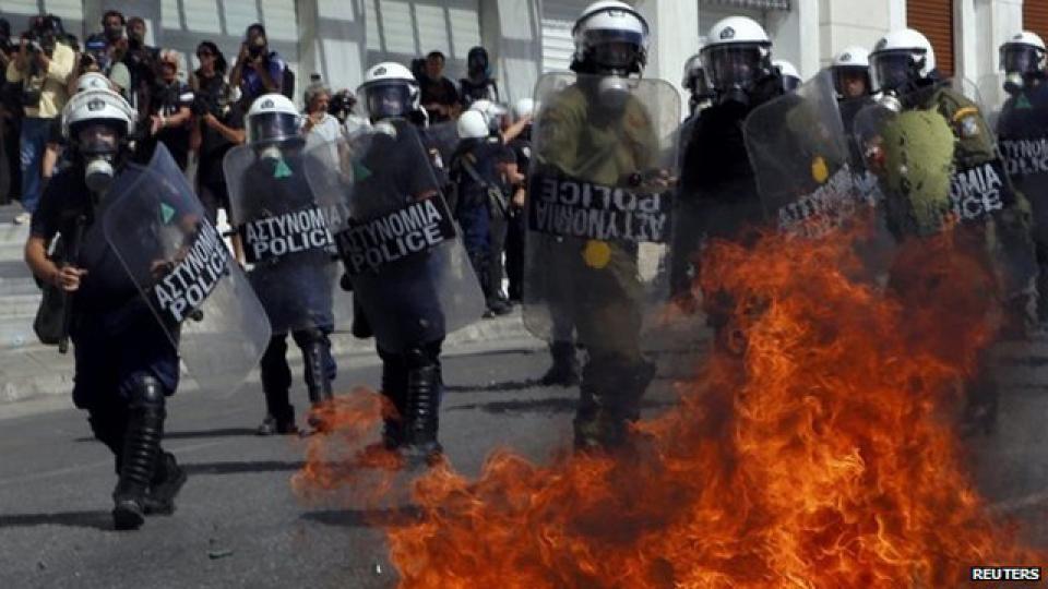 Petrol bombs thrown by protesters explode near riot police on Syntagma Square.