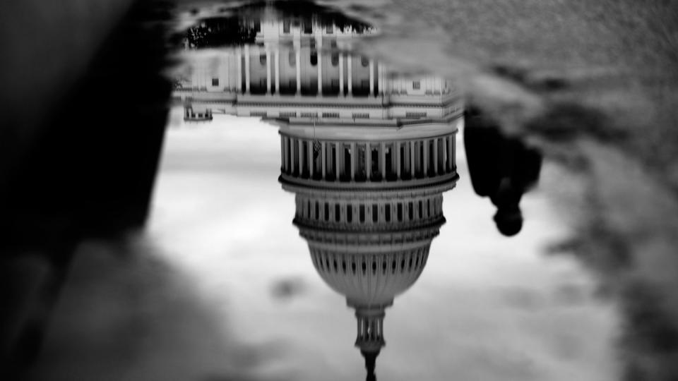 The U.S. Capitol is reflected in a puddle next to the Capitol Reflecting Pool in Washington, D.C., Oct. 15, 2013. Photo: Andrew Harrer/Bloomberg/Getty Images